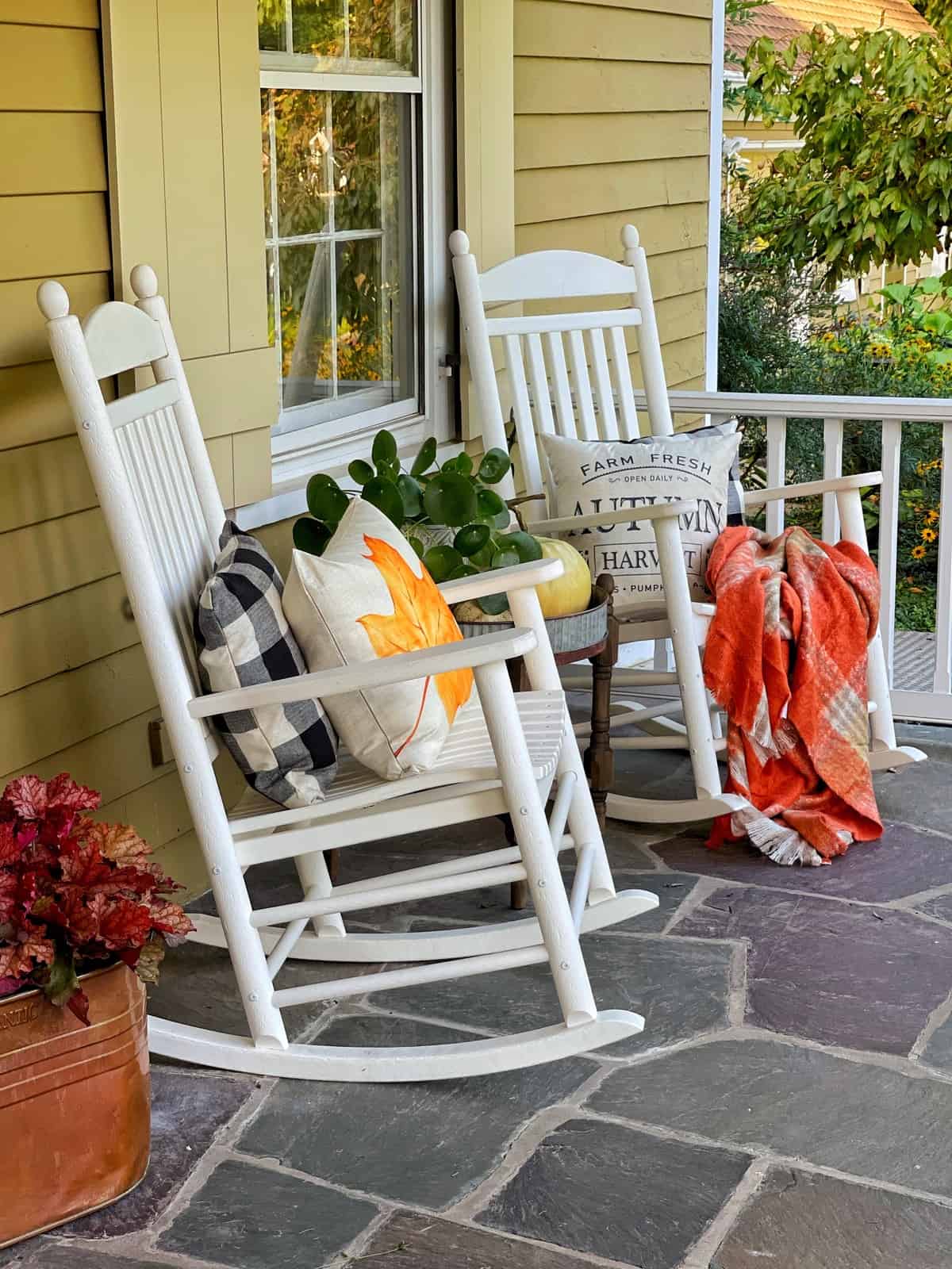 fall porch rockers with throw pillows and blanket