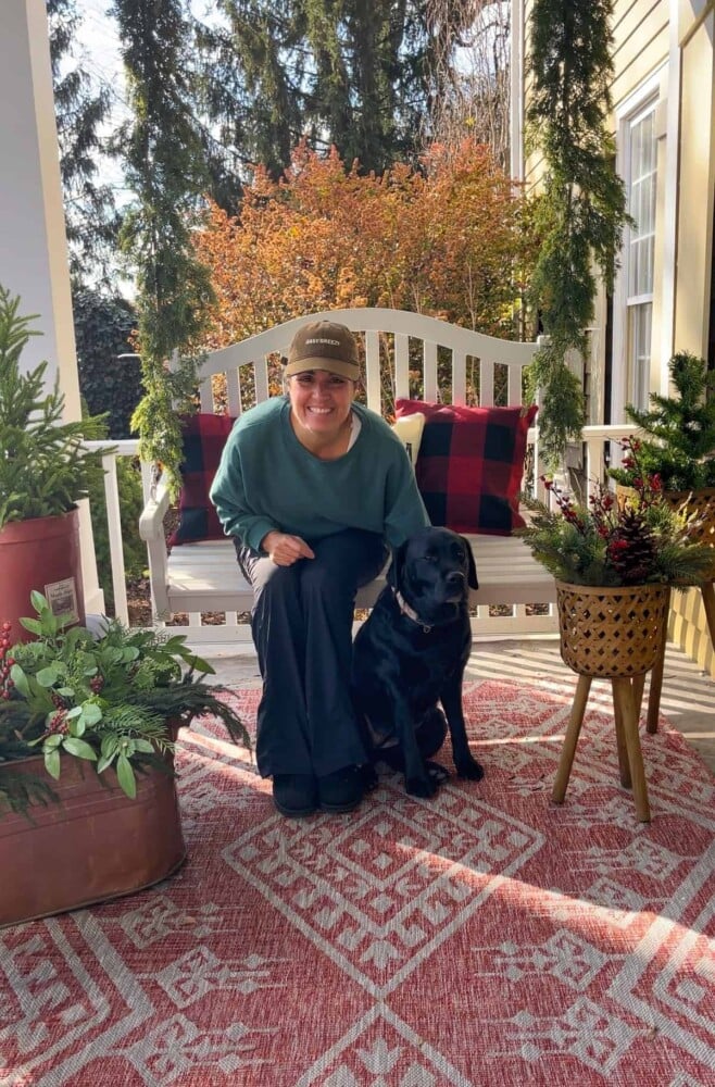 blogger stacy ling with black lab on front porch swing decorat4ed for CHristmas