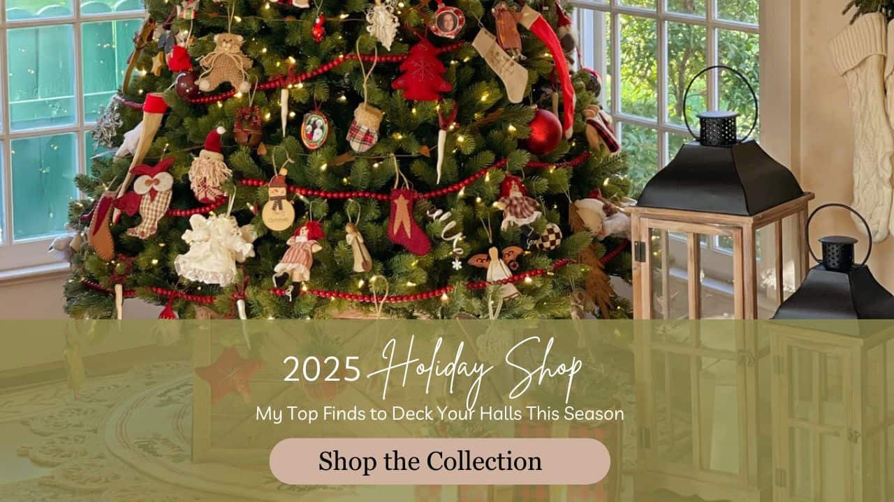 A decorated Christmas tree stands by large windows, adorned with ornaments and lights. Two black lanterns sit nearby. Text overlay reads: "2025 Holiday Shop—My Top Finds to Deck Your Halls This Season. Shop the Collection.