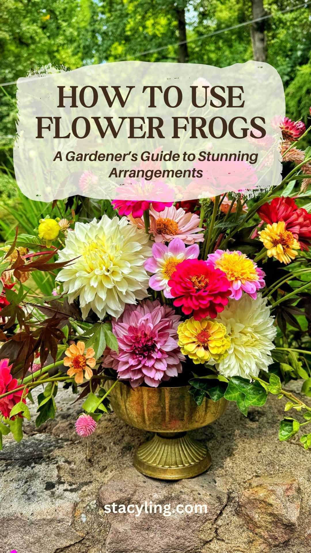 A vibrant floral arrangement with dahlias and zinnias in pink, white, and yellow, set in a gold vase outdoors. Text reads: "How to Use Flower Frogs: A Gardener’s Guide to Stunning Arrangements. stacyling.com".